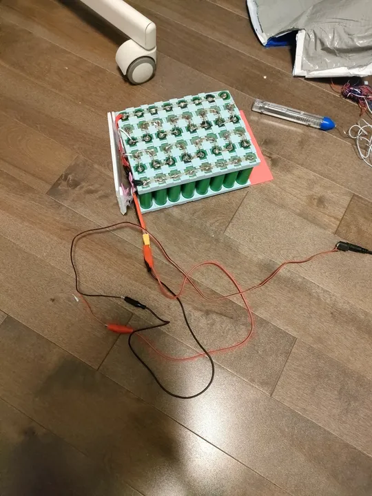 Battery pack being tested with a cheap power adapter and alligator clips